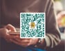 QR-kod ovanpå person med mobil – information om teijas medlemsapp Min Föreningsapp